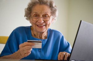 Ältere Frau bezahlt online mit Kreditkarte
